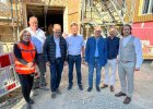 Gruppenbild vor einem im der Sanierung befindlichen Bauwerk