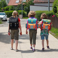 Drei Kinder - zwei Jungen und ein Mädchen - laufen auf der Straße