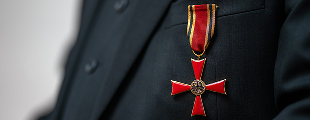 Die Regierung von Oberfranken prüft die Ordenswürdigkeit vorgeschlagener Personen Das Verdienstkreuz am Bande, getragen von einem Mann mit Anzug