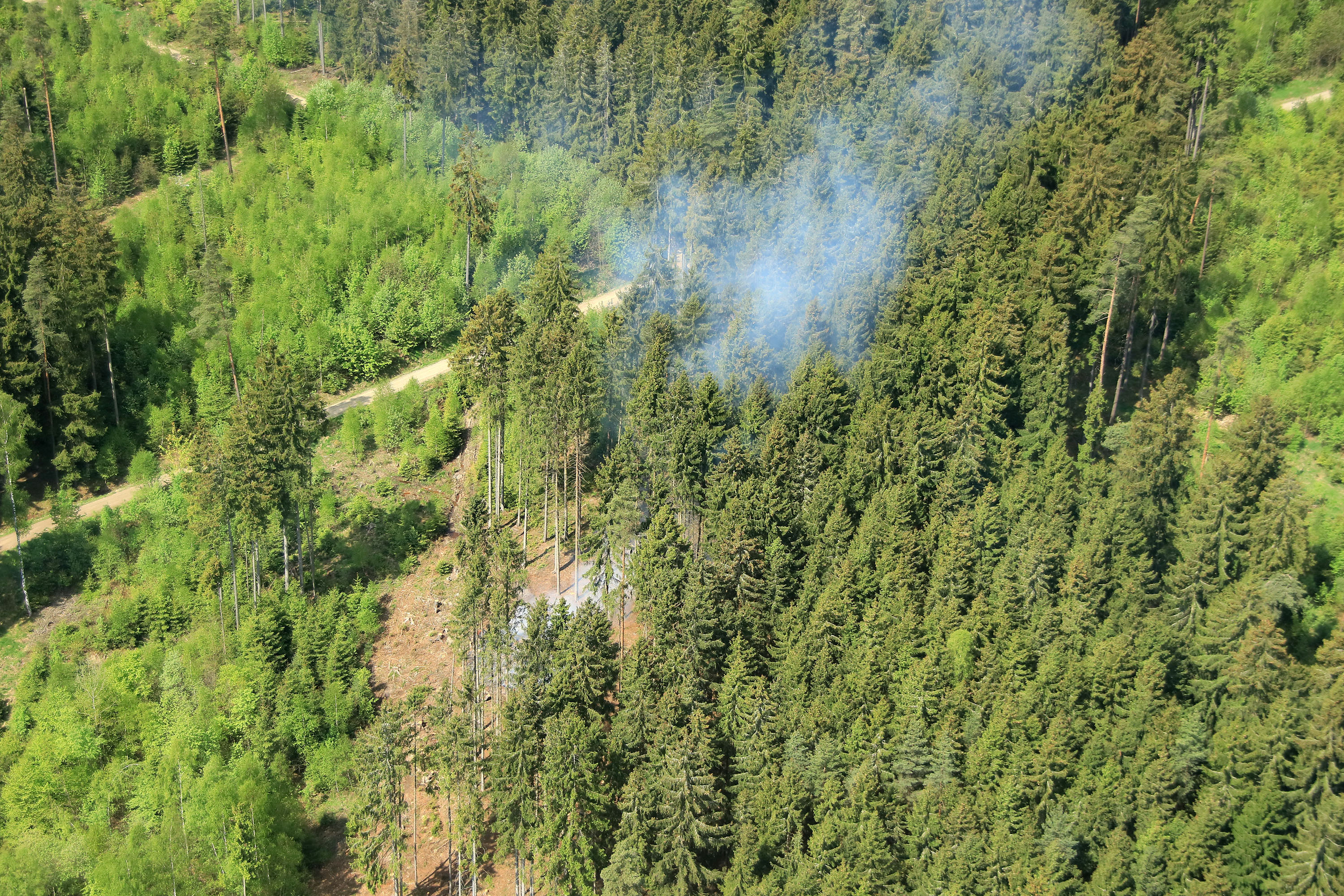 Wegen hoher Waldbrandgefahr: Beobachtungsflug über einem oberfränkischen Waldgebiet. Rauch, der aus einem Waldstück aufsteigt.