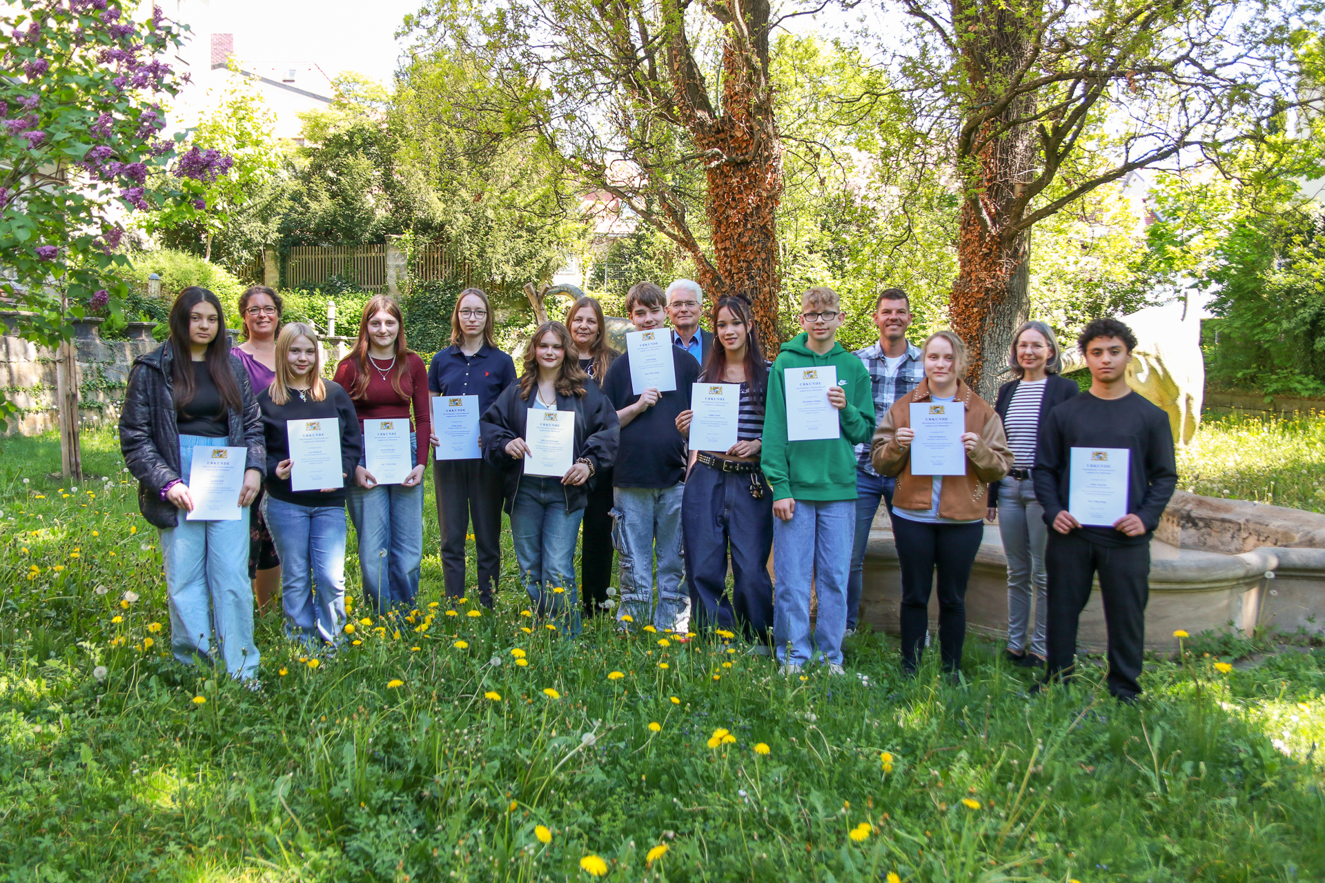 Gruppenfoto aller Teilnehmenden der Endrunde, v.l.: Angelina Wolf, Christine Norwood (Jury), Lea Schoberth, Sarah Fairbrother, Frida Ganser, Julie-Ann Hammoud, Simone Weiner (Jury), Noah Seuling, Stefan Kuen (Regierung von Oberfranken), Sophia Ultsch, Maximilian Schilling, Stefan Klerner (Jury), Varvara Kunaeva, Kathrin Sigg (Re-gierung von Oberfranken), Jaafar Alzarkali Frühlingswiese mit Gruppenfoto aller Teilnehmenden der Endrunde