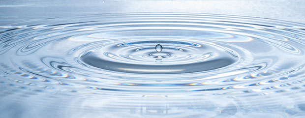 Ein Wassertropfen im Zentrum von Wellenbewegungen