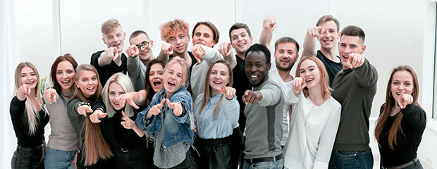 Symbolfoto: Viele junge, glückliche Menschen zeigen mit dem Finger auf den Betrachter