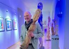Der Künstler Waßmann hält eine seiner Holzskulpturen hoch