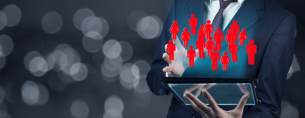 Organisation der Bezirksregierung Symbolfoto für Organisation: Mann mit Anzug hält ein Tablet, das ganz viele Personen-Icons anzeigt